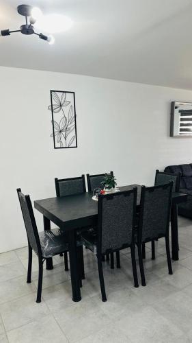 a black dining room table and chairs in a room at Comfortable house in Zaragoza