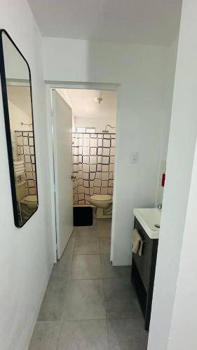 a bathroom with a mirror and a sink and a toilet at Comfortable house in Zaragoza