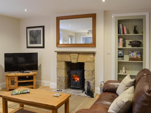 un soggiorno con camino e specchio di Park Farm Cottage a Folkton