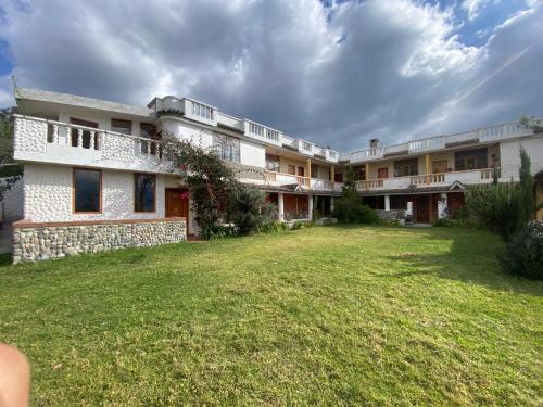 a large building with a yard in front of it at Hostal Curiñan in Otavalo