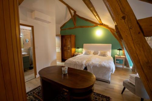 a bedroom with a bed and a table in it at Domaine Chapelle in La Chapelle-la-Reine