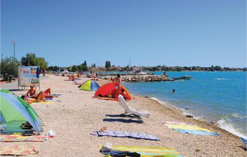 a group of people on a beach with tents at Stunning Apartment In Vrsi Mulo With Wifi in Kod Mula