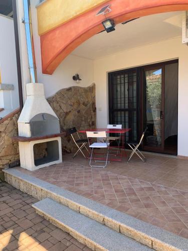 a patio with a pizza oven and a table at Sa Domo De Lory in Torpè