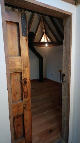 an open wooden door in a room with a ceiling at The Dovecote - unique self-contained 1bed renovated barn in Saffron Walden