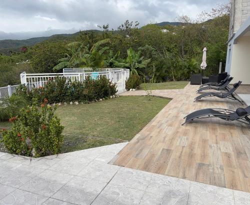 a patio with two lounge chairs on a house at ALLAMANDA DES BOIS in Deshaies