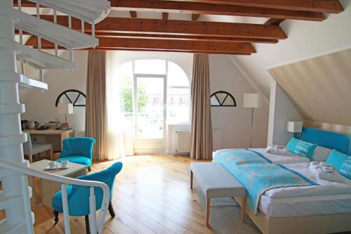 a bedroom with a bed and a table and chairs at Hotel Villa WellenRausch in Travemünde