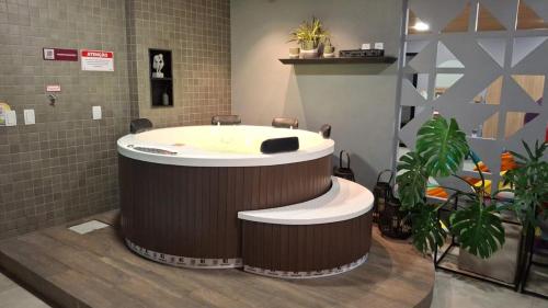 a large tub in a room with some plants at Studio Aconchegante 200m praia Pajuçara e P Verde in Maceió