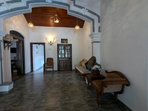 a living room with a couch and chairs in a room at Sea Turtles Bungalow in Induruwa