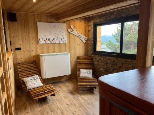 a room with chairs and a stove in a cabin at Chalet cosy Spa & Sauna privatifs Les Angles in Les Angles