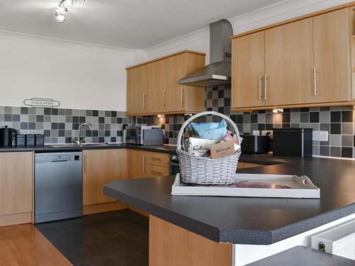 a kitchen with a basket of groceries on a counter at Dunlin Haven in Sandside