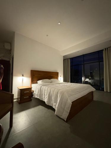 a bedroom with a large bed and a large window at Reiss Villa Kandy in Kandy