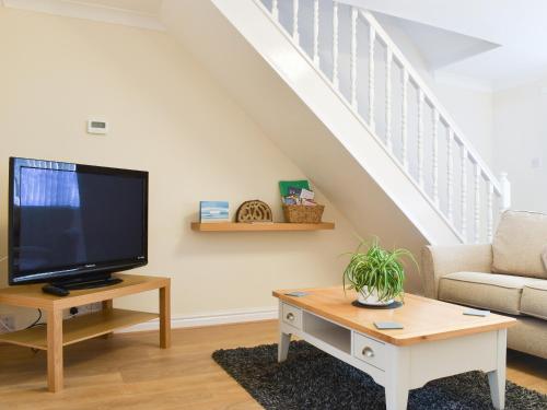 a living room with a tv and a couch at Filey Central One - Uk31706 in Filey
