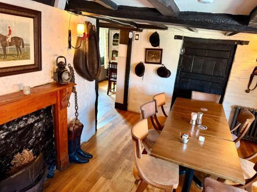 a dining room with a table and a fireplace at The George and Dragon Pub in Shipley