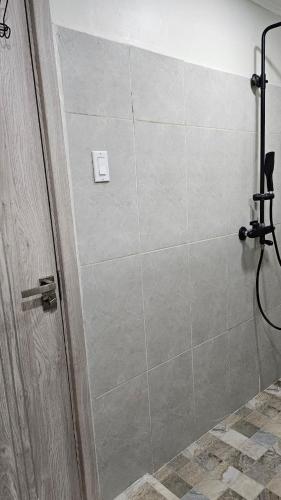a shower with a glass door in a bathroom at The Blue Donkey in Paramaribo