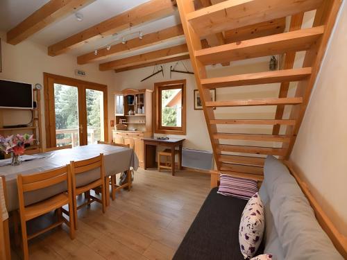 a living room with a dining room table and a staircase at Chalet De Montagne 14 Couchages in La Morte