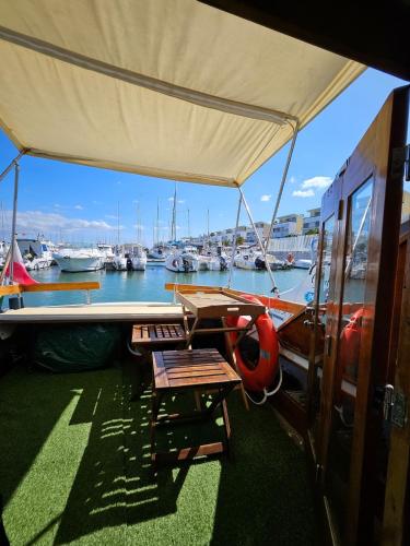 a boat with a table and chairs on a marina at Lisboa Barco Corleone in Lisbon
