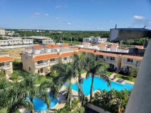 an aerial view of a resort with a pool and palm trees at Residencial Las Estrellas in Boca Chica