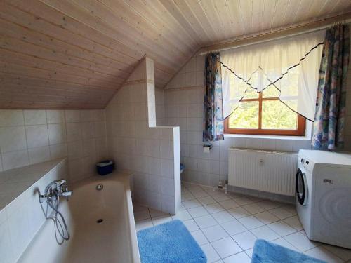 a small bathroom with a tub and a window at Ferienwohnung Fichtelwald in Fichtelberg