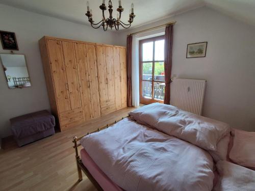 a bedroom with a bed and a window and a chandelier at Ferienwohnung Fichtelwald in Fichtelberg