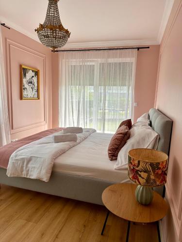 a bedroom with a large bed and a window at Notting Hill Apartament in Rzeszów