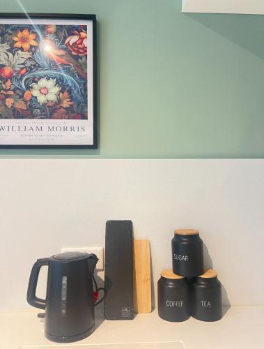 a shelf with two coffee cups and a picture at Dimoro Family Suites - Designed for your comfort in Essen