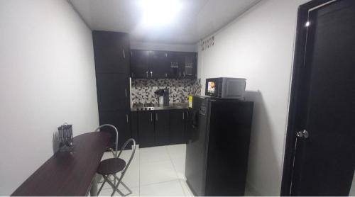 a kitchen with a black refrigerator and a table and chairs at Apartamento en Aranjuez cómodo y tranquilo in Medellín