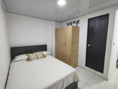 a bedroom with a bed and a wooden cabinet at Apartamento en Aranjuez cómodo y tranquilo in Medellín