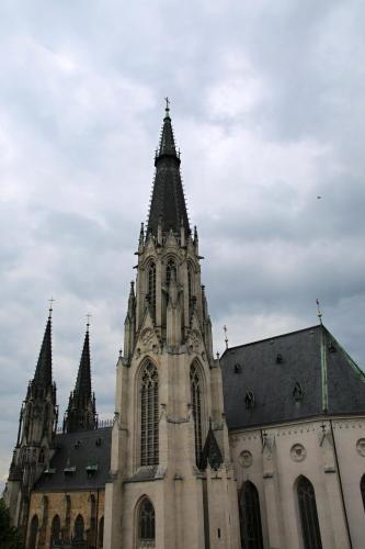a church with a tower and a building with turrets at Hotel Palác in Olomouc