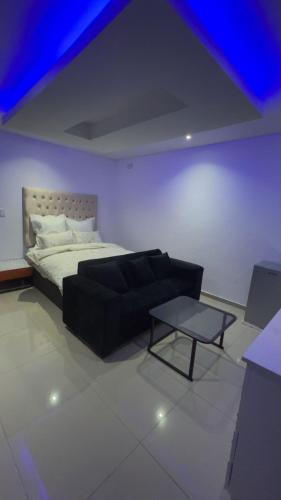 a bedroom with a bed and a couch and a table at Made Stays in Four Ways