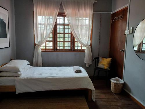 a bedroom with a white bed and a window at Serene Mountain Retreat in KL - Entire House for Rent in Kampong Kelang Gates Baharu