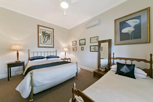 a bedroom with two beds and a mirror at Hillside Country Retreat in York