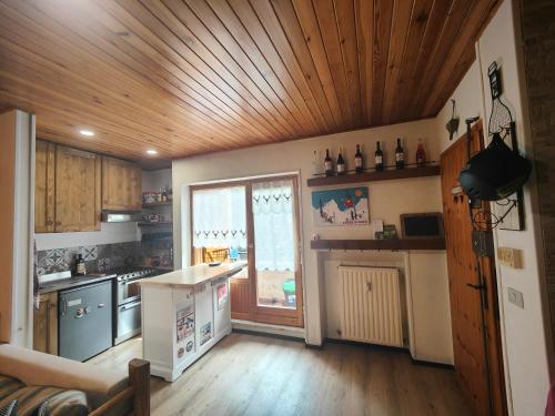 a kitchen with a wooden ceiling and wooden floors at Alpina Loft in Sauze d'Oulx in Sauze dʼOulx