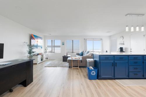 a kitchen with blue cabinets and a living room at Crescent Beach Motel in Crescent City