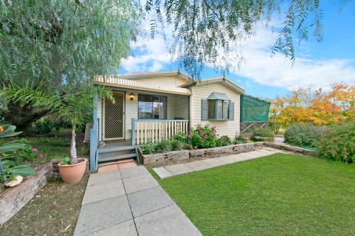 a small house with a porch and a yard at Hillside Country Retreat in York