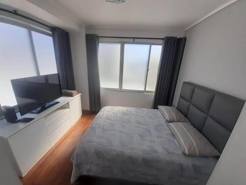 una camera da letto con un letto e una TV a schermo piatto di Exclusivo Departamento en Edificio Alessandria a Cochabamba