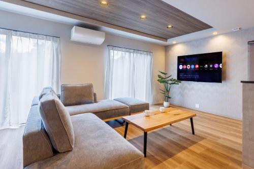 a living room with a couch and a table at 最大12名OK 駐車3台無料自然豊かな名護エリアの広々一棟貸し Marama Ryukyu 琉球 in Nago
