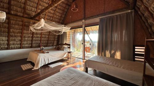 a bedroom with two beds in a room with a window at Nomads Village, Macapa in Luis Correia