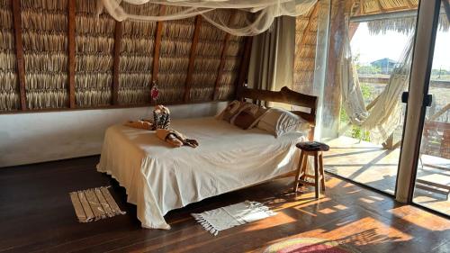 a woman is sitting on a bed in a room at Nomads Village, Macapa in Luis Correia