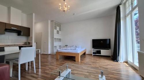 a living room with a table and a television at Loft with balcony Enckekaserne in Magdeburg