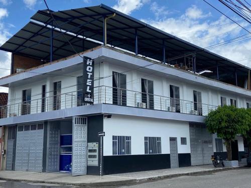 a white building with a balcony on a street at Hotel Crystal Acacias in Acacías