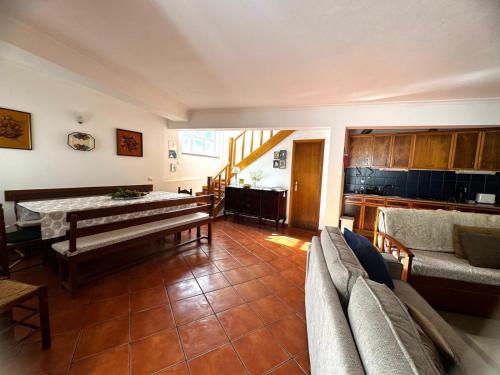 a living room with a table and a couch at Casa das Oliveiras - Manteigas in Manteigas