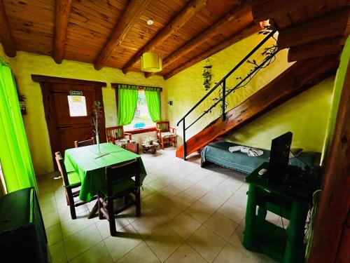 a living room with a green table and a couch at Complejo Peuma Hue in Lago Puelo