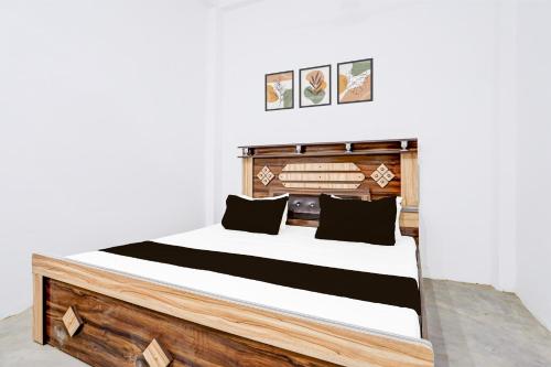 a bedroom with a wooden bed with black pillows at SPOT ON Ma Sharda in Phāphāmau