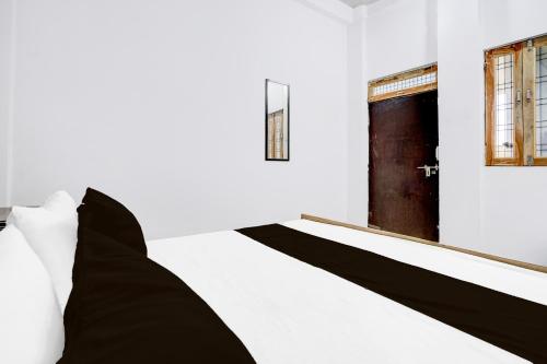a bed with black and white pillows in a room at SPOT ON Ma Sharda in Phāphāmau