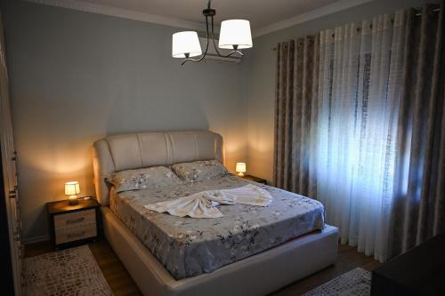 a bedroom with a bed with two night stands and two lamps at Olive Tree in Tirana