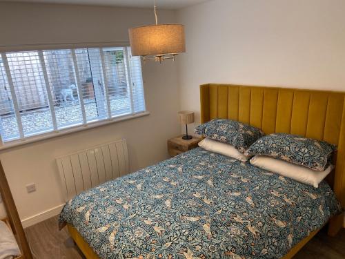 ein Schlafzimmer mit einem Bett mit Kissen und einem Fenster in der Unterkunft Luxury Apartment St Andrews in St Andrews