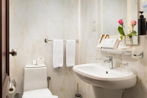 a white bathroom with a sink and a toilet at Emaar Elite Al Madina Hotel in Al Madinah