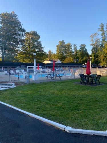 a park with benches and picnic tables on the grass at Barberry Court Motel &Cabins in Lake George