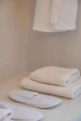 two white towels sitting on a counter in a bathroom at Skalia Mountain & Sea Suites in Skaliá