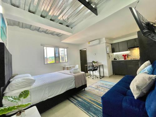 a bedroom with a bed and a blue couch at Loft Boutique Rooftop I Gym I Laureles I MedView in Medellín